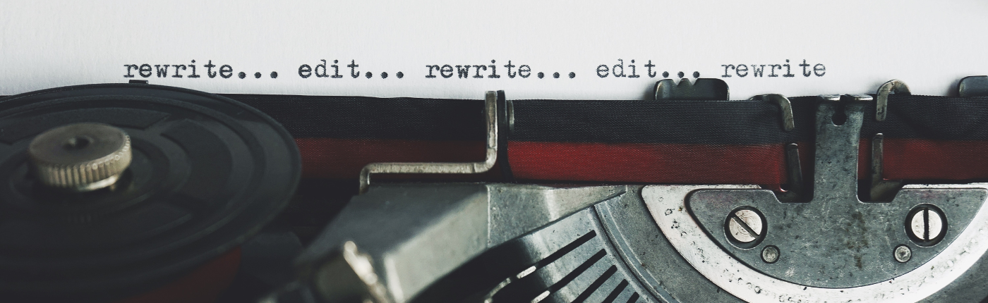 close up view of an old fashioned typewriter with text that reads rewrite edit